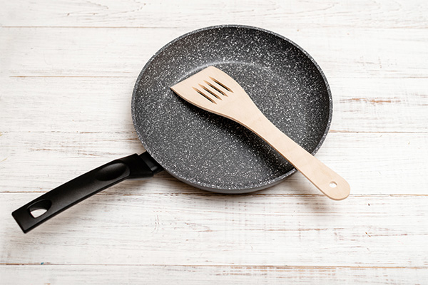 Ceramic pan and wooden spatula