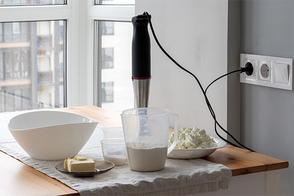 Immersion blender and containers on table